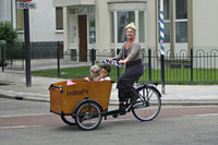 Mevrouw op een bakfiets met twee kinderen