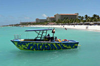 Speedboat in water voor het strand, Palm Beach, Aruba