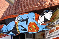 Afbeelding van vliegende superman (stripfiguur) op houten bord